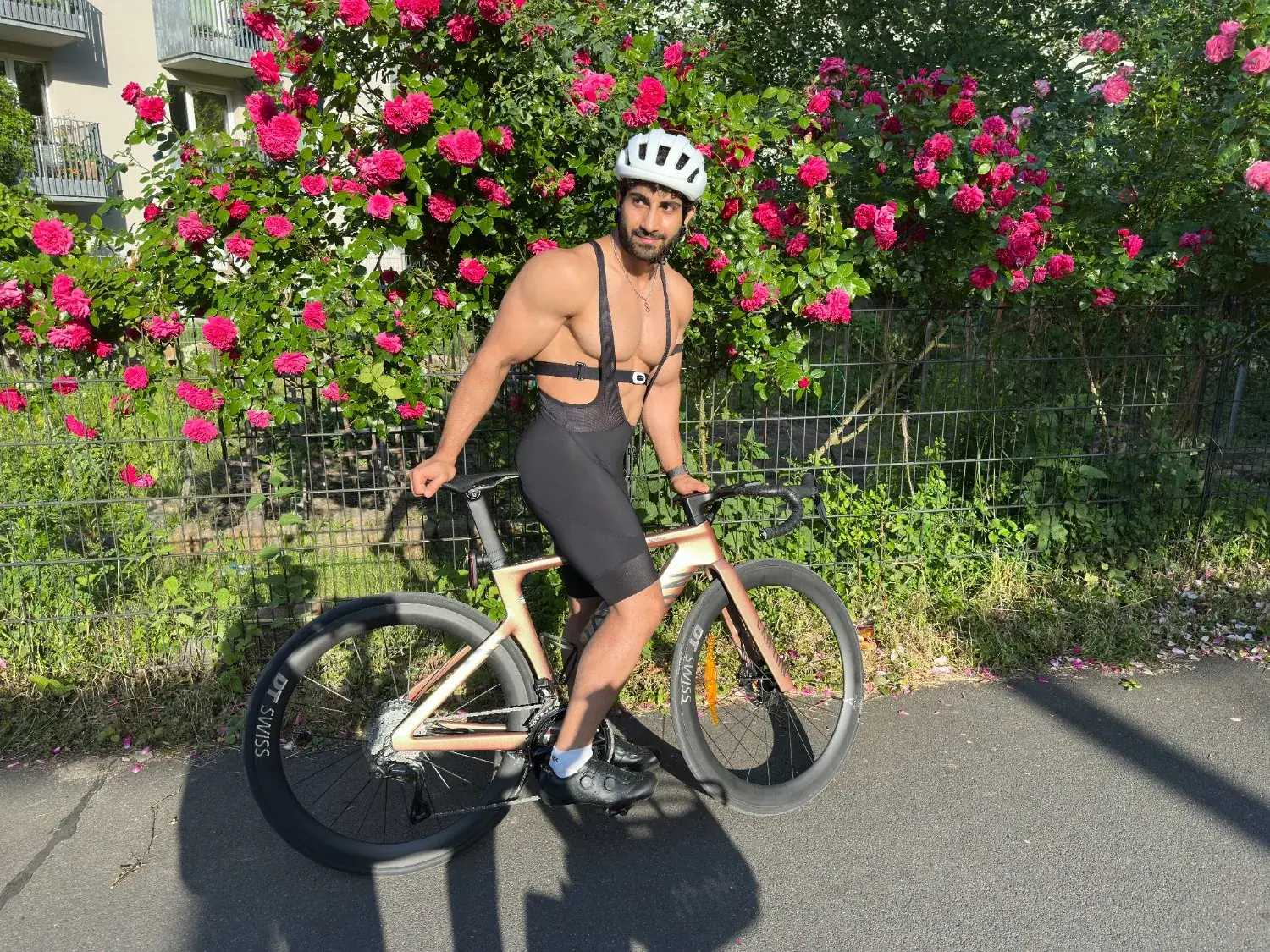 On the road bike in front of a wall of roses in Berlin.