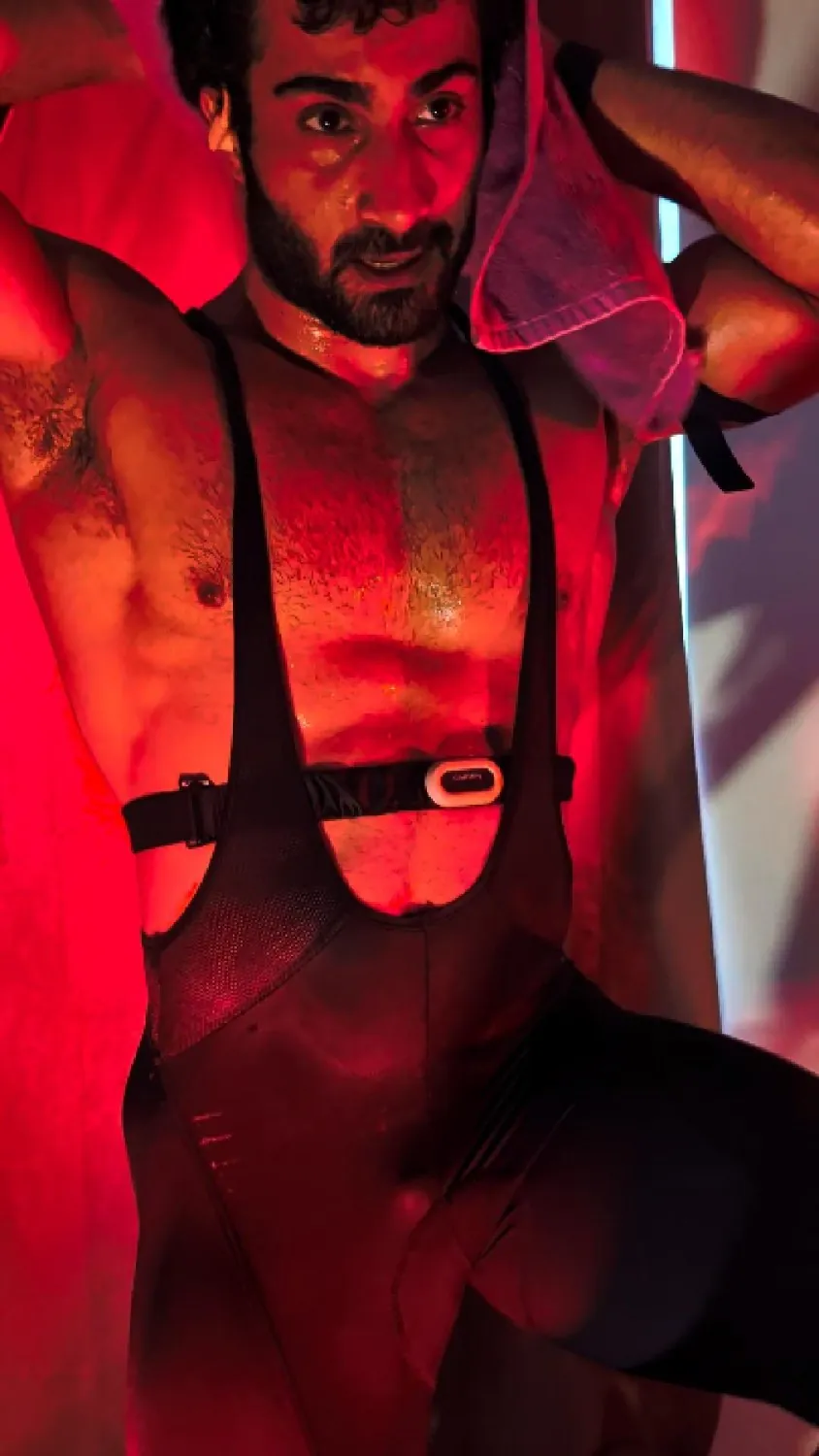 Portrait in cycling kit under red light.